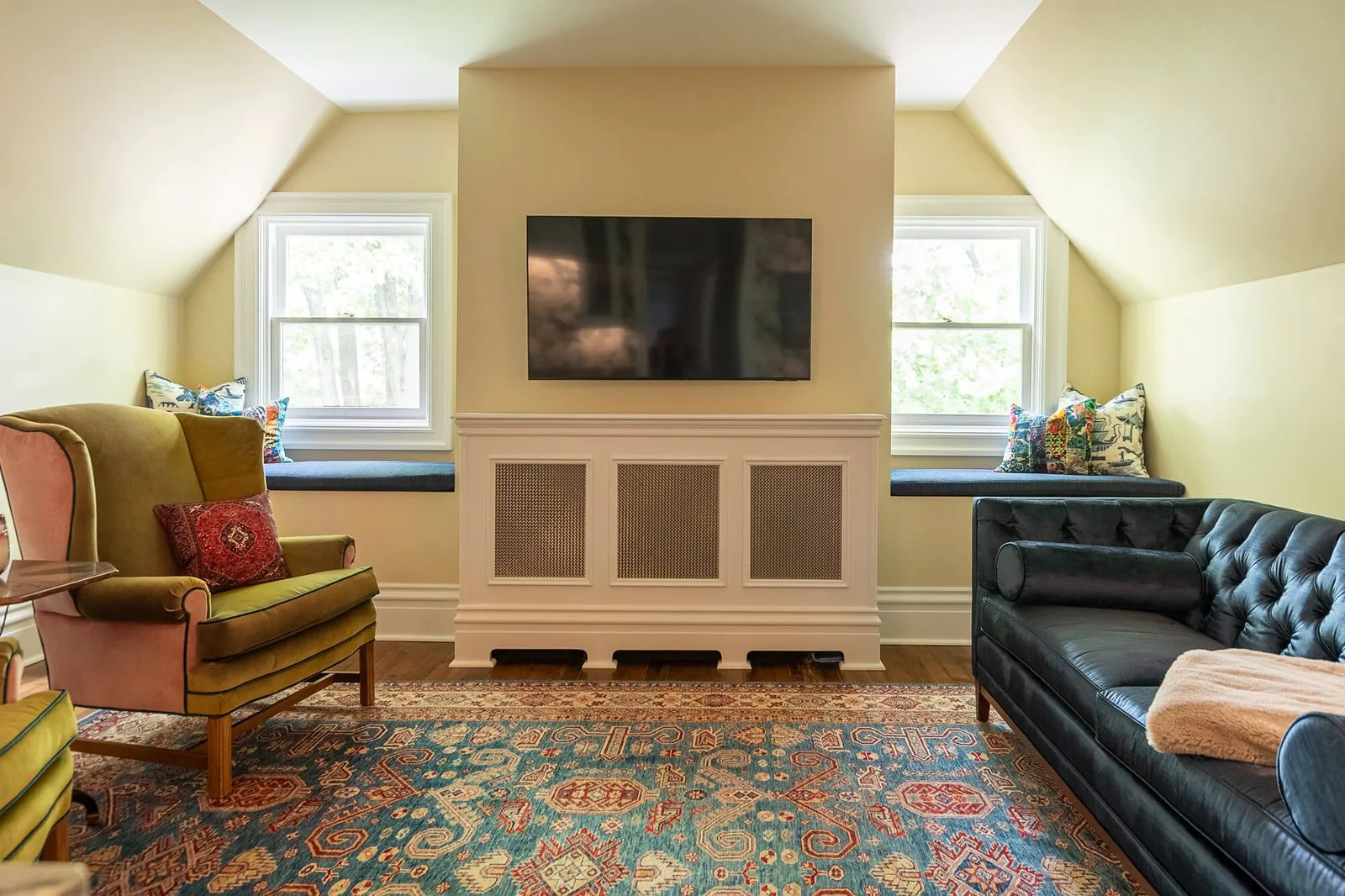 Finished sitting room with a fireplace, built-in cabinetry and a patterned rug