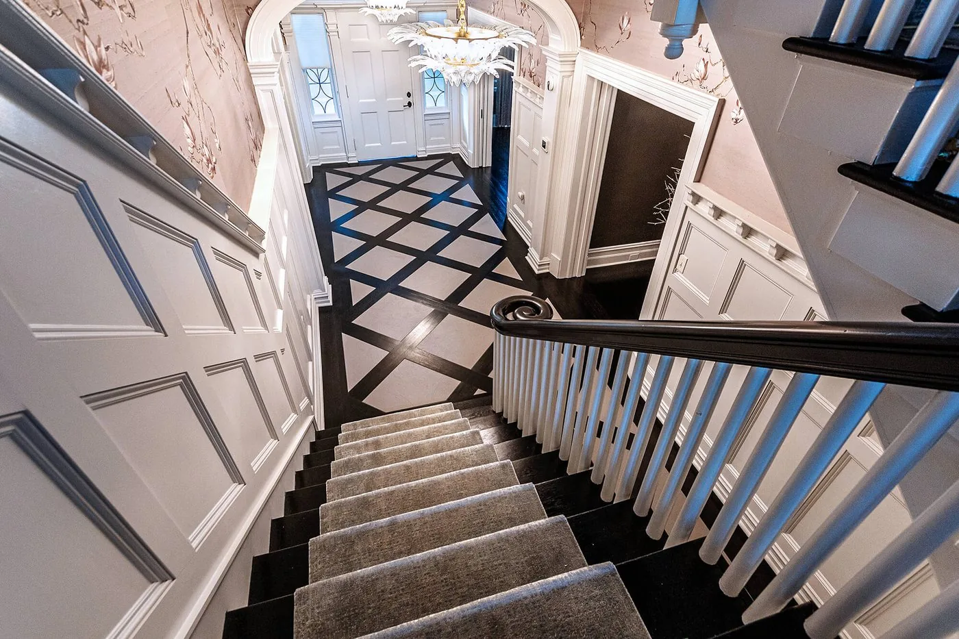 Stair with a graphic floor below and a painted balustrade