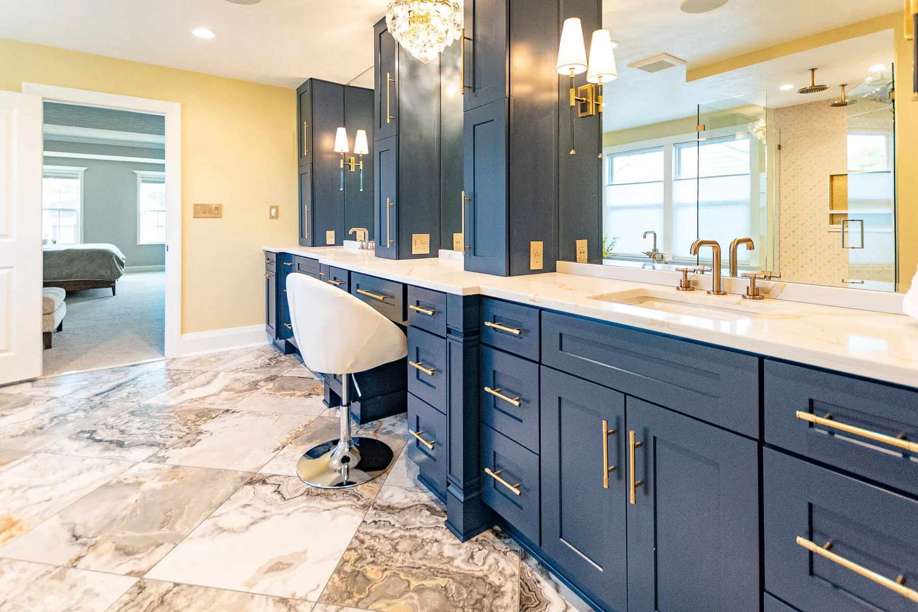Marble bathroom with a double vanity in painted navy cabinetry