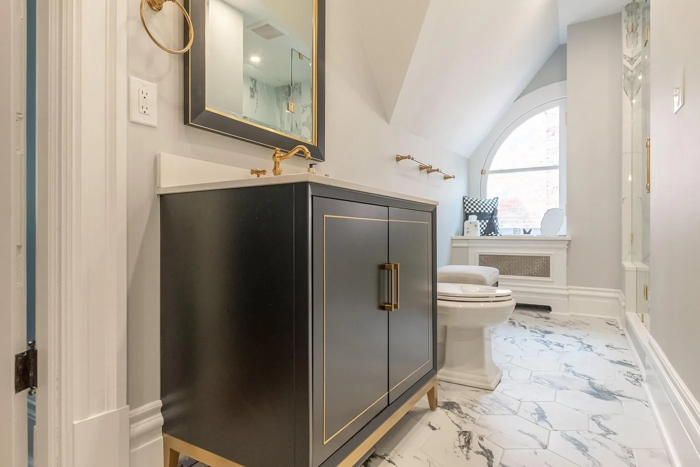 Bathroom with a dark vanity and a marble surround