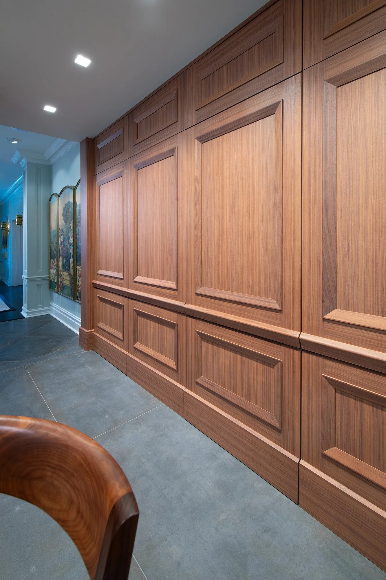 Walnut paneled wall running the length of a room