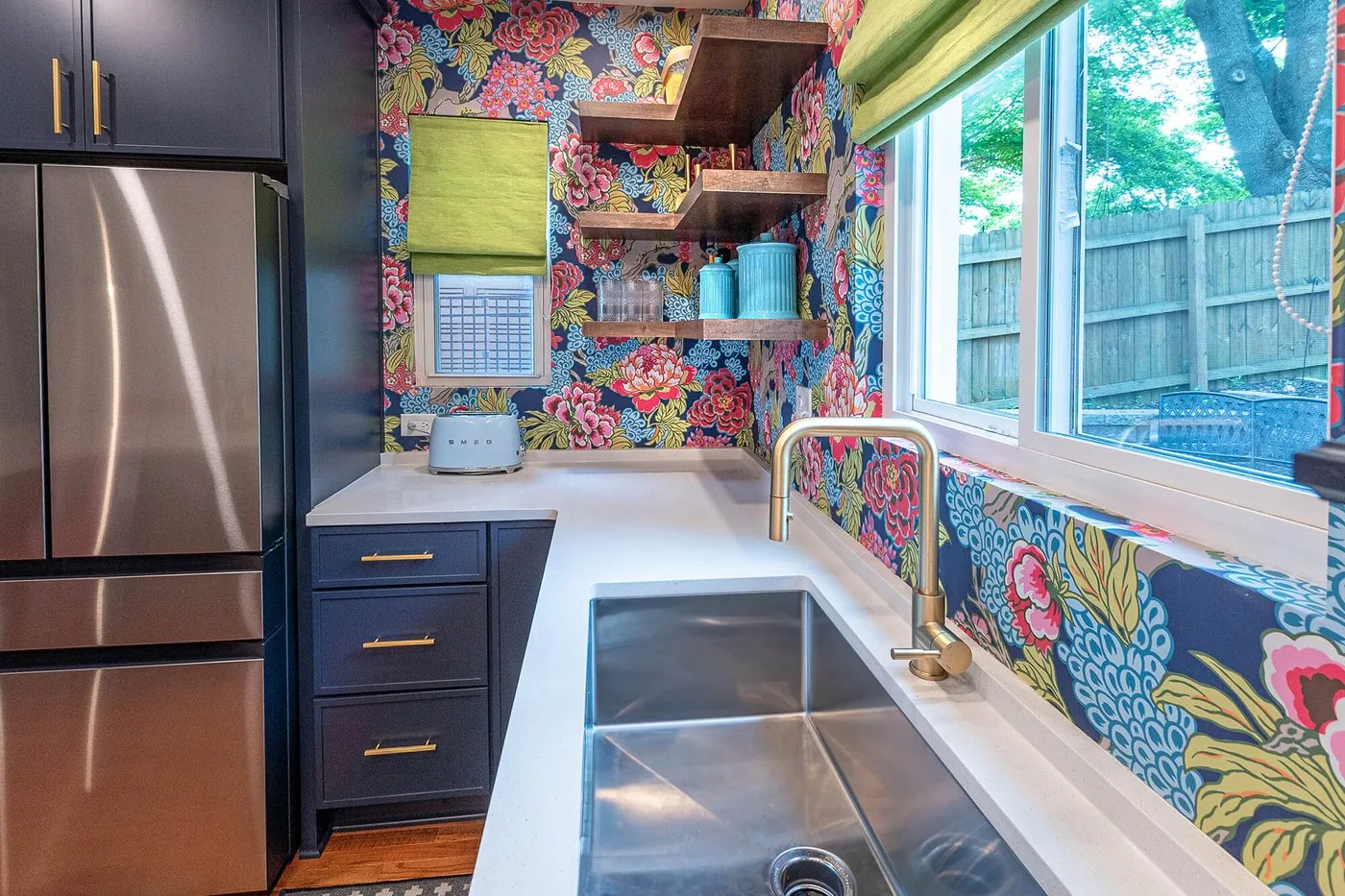 Galley kitchen with a stainless sink and patterned wallpaper