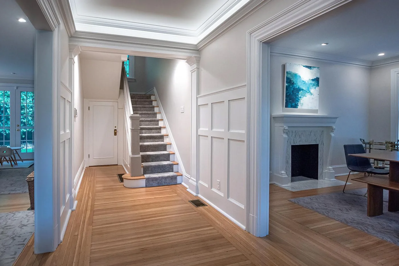 Entry with a painted stair and wood floors