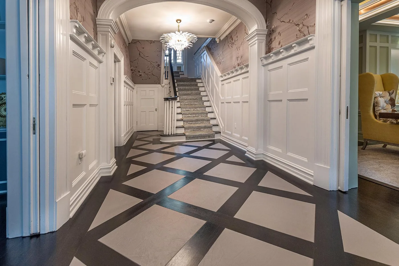 Hallway with a patterned floor leading to a stair