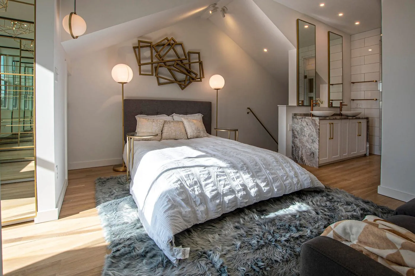 Bedroom with a low bed, sconces and a dressing area beyond